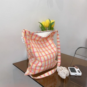 Detail of yellow and pink plaid cotton tote bag featuring a simple wish woven label