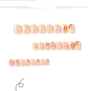 Close-up of pink heart and floral press-on nails with wave patterns and smiley face art