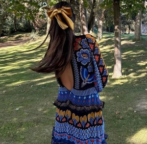 Detailed back view of a floral print long sleeve dress with a deep V open back design