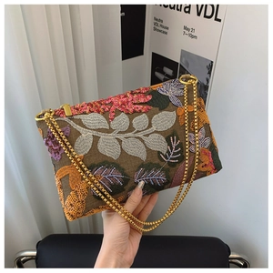 Detail of embroidered floral clutch with sequins and detachable gold chain strap