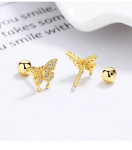 Macro view of gold butterfly screw back stud earrings with shimmering white zircon stones