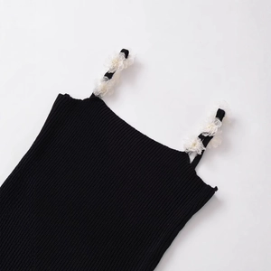 Black ribbed knit camisole top with white floral accents on shoulder straps