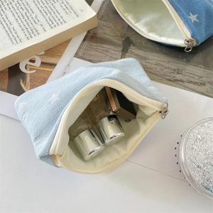 Internal view of light blue corduroy pouch with beige lining storing cosmetics