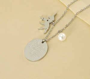 Detail of silver unicorn necklace with pearl and 'She believed she could' engraving