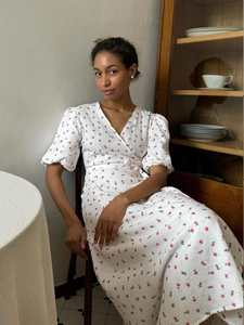 Detailed view of floral print wrap dress with puff sleeves and elastic waist tie