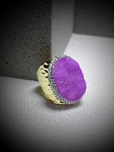 Detailed close-up of a purple druzy crystal ring with golden hammered metal texture