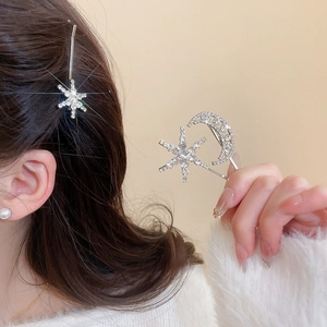 Detailed view of silver star and moon hair clips set with sparkling rhinestones