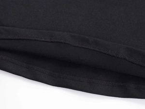 Dettaglio ravvicinato della doppia cucitura su tessuto a maglia elastico nero del top