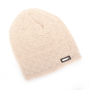 Detail der beige Strickmütze mit quadratischer Waffelstruktur und Metallplakette