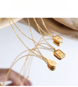 Macro detail of 18K gold necklaces featuring geometric pendants with starburst engravings