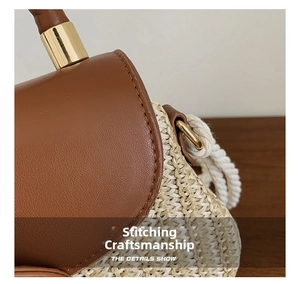Detailed view of leather and straw stitching with golden metal buckle and woven handle
