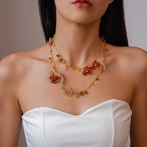 Detail of vintage double-layer necklace featuring amber acrylic flowers and gold beads