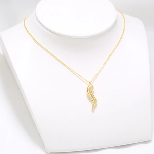 Polished 18K gold-plated chili-shaped necklace with crystals on white mannequin