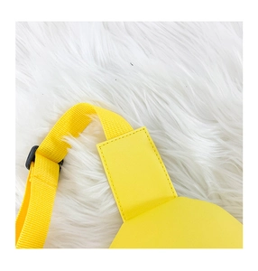 Detail of yellow nylon strap with black adjustable buckle and neat stitching on PU leather