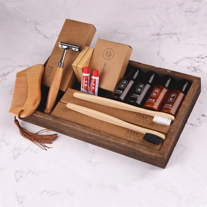 Bamboo hotel amenity set with wooden comb and toiletries on marble background