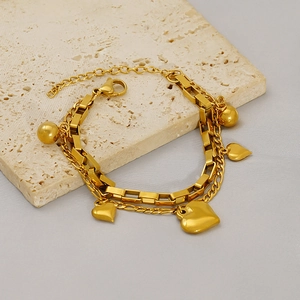 Détail d'un bracelet double couche en titane doré avec cœurs et perles sur pierre