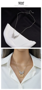 Detail view of gold and silver butterfly pendants with zircons on stainless steel chains