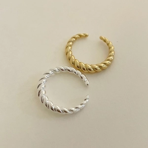 Detailed top view of twisted knot open rings in polished gold and silver finishes