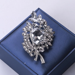 Elegant silver alloy crystal brooch with teardrop floral design on a blue jewelry box