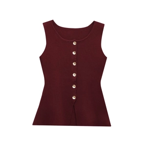 Détail de la maille côtelée bordeaux et des boutons métalliques sur le gilet ajusté