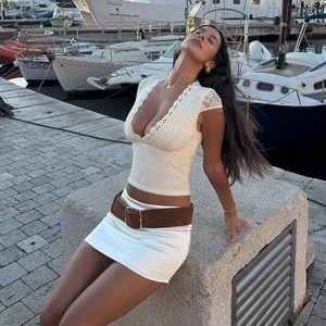 Top sexy in pizzo bianco con scollo a V e gonna in raso al porto turistico all'aperto