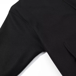 Detail van de schouder- en mouwnaad van een hoogwaardige losse zwarte trenchcoat