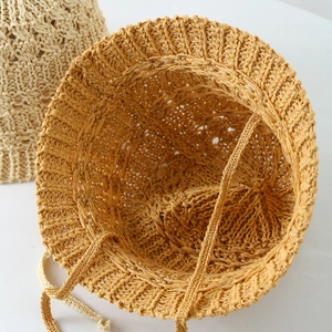 Dettaglio dell'interno di un cappello a secchiello in paglia con cordino sottogola intrecciato