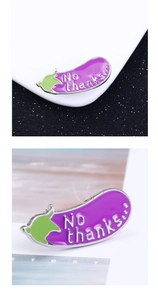 Detailed macro of a purple enamel eggplant pin with silver trim and No Thanks text