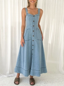 Dettaglio dell'abito lungo in denim blu con bottoni anteriori e grandi tasche laterali