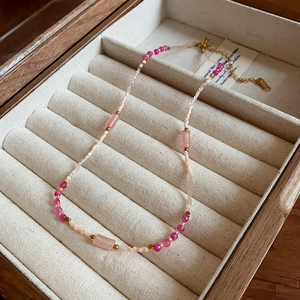Detailed view of handmade pink agate pearl necklace in a wooden velvet jewelry box