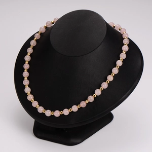 Pink energy stone beaded necklace with gold spacer beads on a professional black bust display
