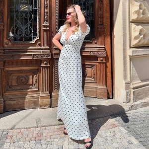 Robe longue blanche élégante à col en V avec pois noirs et manches bouffantes