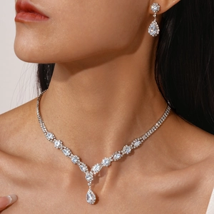 Close-up of elegant zircon drop necklace and earrings set on model with luxury finish