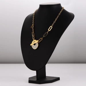 Golden OT clasp necklace with diamond-encrusted circle pendant on black mannequin