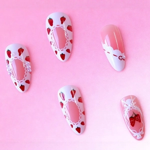 Sweet almond press-on nails featuring strawberry patterns, pearls, and pink bow designs