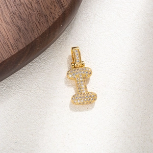 Macro shot of gold-plated letter I pendant with micro-pave cubic zirconia crystals