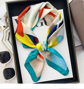 Detailed view of an elegant silk scarf with geometric patterns tied in a chic bow knot