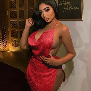Detailed view of red sequin halter dress with backless cut and side slit on a model