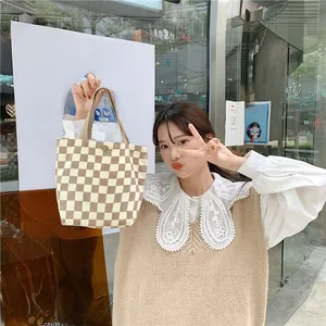 Close-up of the beige and white checkerboard knit corduroy tote bag with thick handles