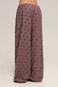 Détail du pantalon large rose poudré avec flocage de cœurs 3D et taille élastique