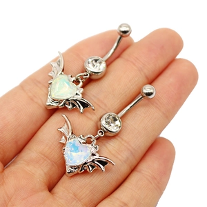 Detail of two bat-winged heart opal belly rings held against a clean white background