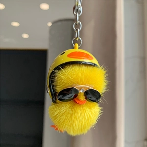 Close-up of plush yellow duck keychain with tiny helmet and diamond sunglasses detail