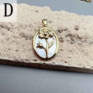 Macro detail of oval gold flower pendant with white mother of pearl inlay on stone