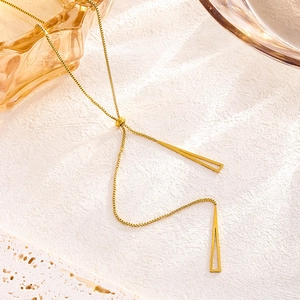 Detailed close-up of golden Y-shape necklace with minimalist triangle pendants