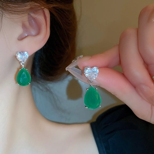 Vintage heart and pear-shaped zircon earrings in silver finish worn by a model