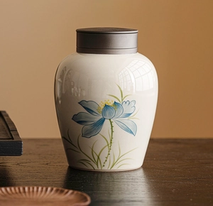 Macro detail of ash-glazed ceramic tea canister with hand-painted blue lotus patterns
