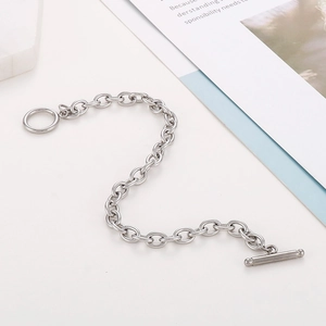 Flat lay of silver stainless steel chain bracelet with OT toggle clasp on white background