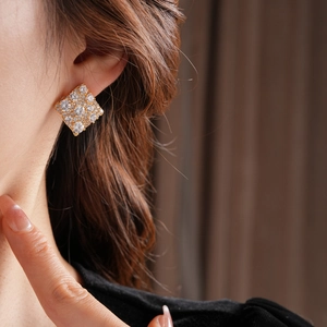 Gros plan de boucles d'oreilles carrées en zircon plaqué or portées par un mannequin
