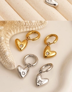 Detailed view of heart-shaped hoop earrings with starburst engraving and small zircon stones