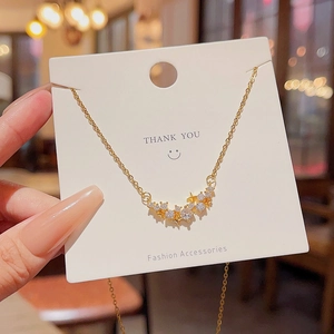Macro view of sparkling zircon star pendant on a gold chain with jewelry card